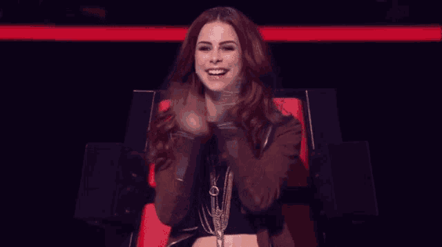 a woman sitting in a chair with her hands on her ears