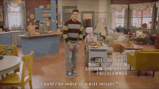 a man in a striped sweater stands in a living room with the words could i be more of a kiss misser below him
