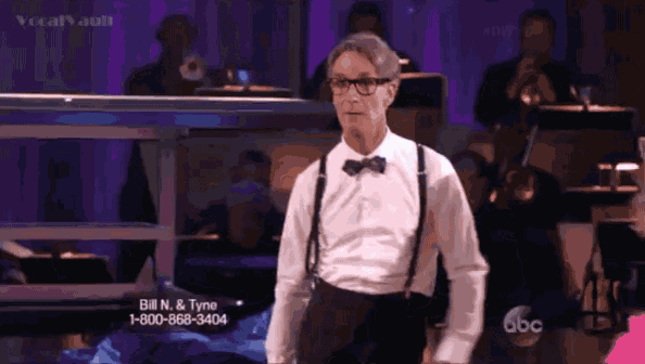 a man wearing suspenders and a bow tie stands in front of an ad for bill n & tyne