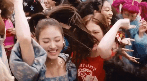 a group of women are dancing in a crowd of people .