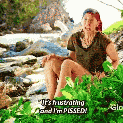 a woman is sitting on a rock in the jungle and saying it 's frustrating and i 'm pissed