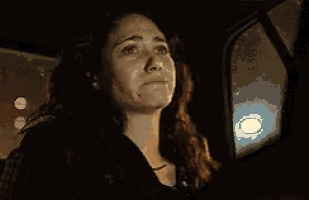 a woman is crying in a car while sitting in the back seat .