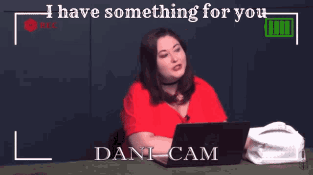 a woman sitting in front of a laptop with the words i have something for you dani cam behind her