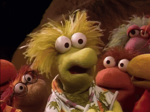 a group of stuffed animals including a muppet with glasses