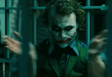 a man with a joker face painted on his face is pointing at the camera