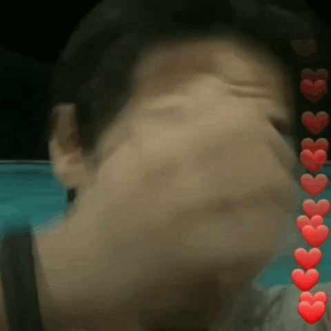 a blurry picture of a person 's face with red hearts coming out of it