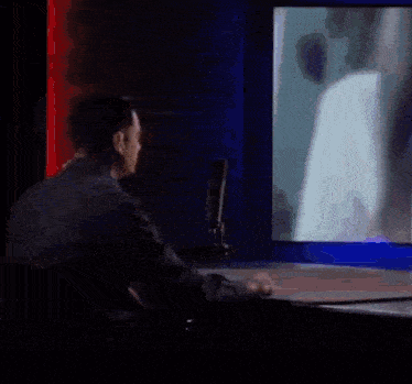a man sitting in front of a microphone with a sign behind him that says shapiro show