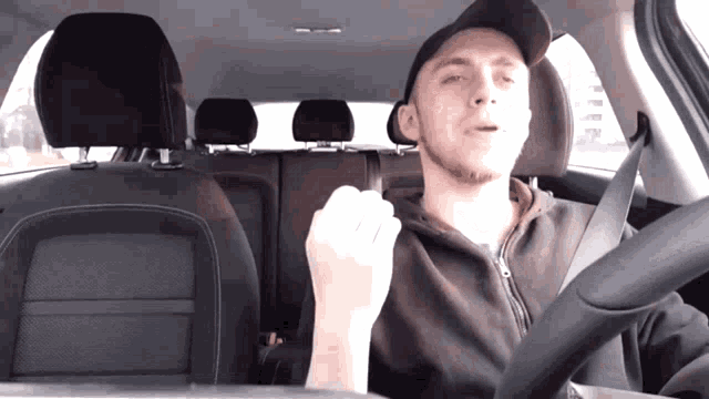 a man in a hat is sitting in a car