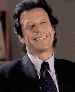 a man wearing a suit and tie is smiling