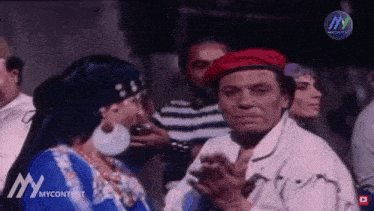 a man wearing a red hat is talking to a woman .