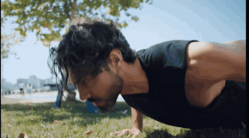 a man is doing push ups in the grass
