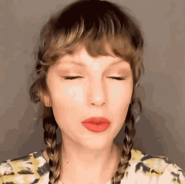a close up of a woman 's face with her eyes closed and braids .