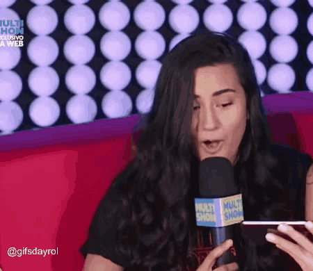 a woman speaking into a microphone that says multi show on it