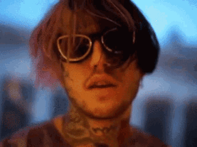 a man with a tattoo on his neck is wearing sunglasses