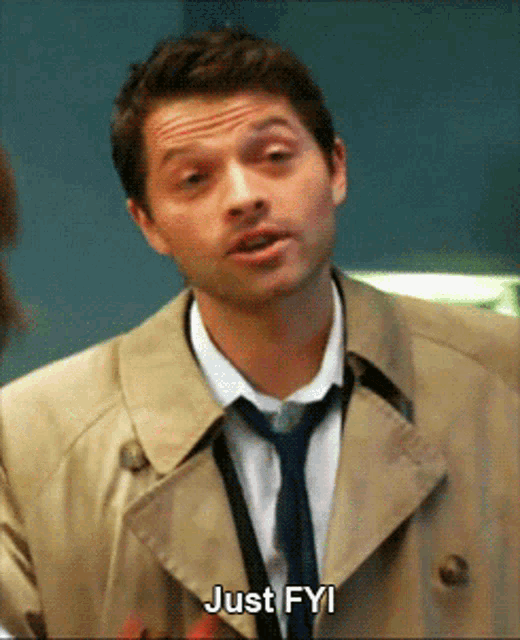 a man wearing a trench coat and tie is saying just fyi