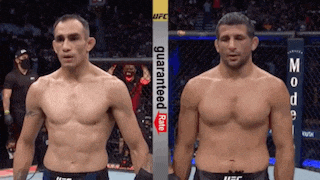 two men standing next to each other in a boxing ring with a banner that says guaranteed rate on it