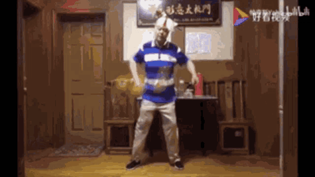 a man is dancing in a room with chinese writing on the wall behind him .