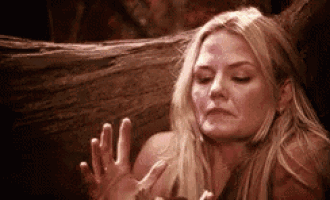 a woman with a bloody face is sitting next to a tree .