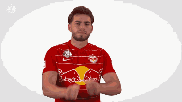 a man wearing a red shirt with a red bull on it