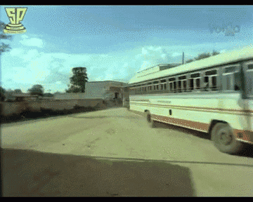 a bus is driving down a dirt road with sp written on the bottom