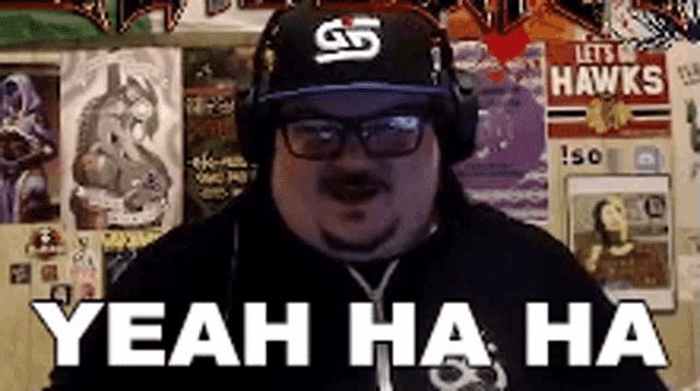 a man wearing a hat and headphones says " yeah ha ha "