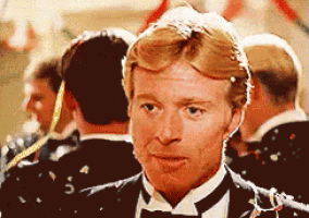 a man in a tuxedo and bow tie is standing in a crowd