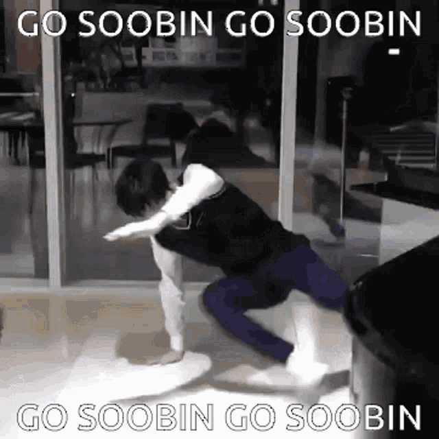 a man is kneeling down on the floor in front of a window with the words `` go soobin go soobin '' written on it .
