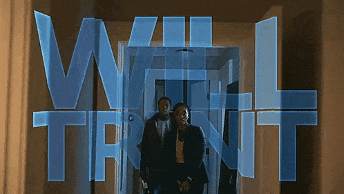 a man and woman are walking through a hallway with the words will trent written on the wall behind them