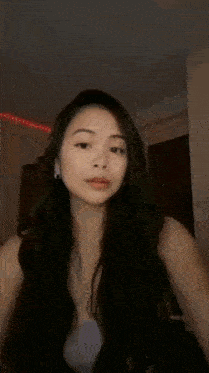a woman with long black hair is wearing a purple tank top with the word sa on it .