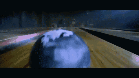 a bowling ball is going down a wooden alley