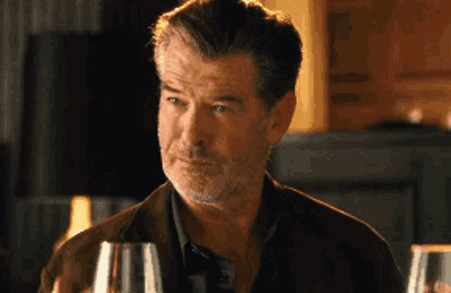 a man with a beard is holding a glass of wine in his hand