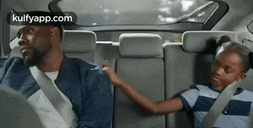 a man and a girl are in the back seat of a car .