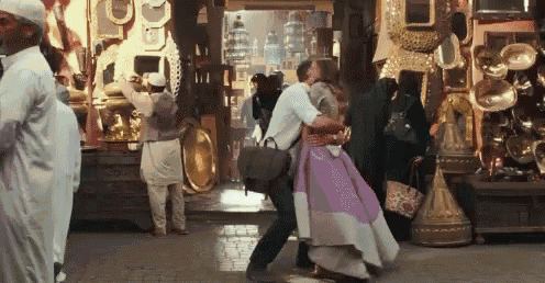 a woman in a purple dress is dancing with a man in a white dress