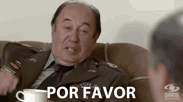 a man in a military uniform is sitting on a couch with a cup of coffee and the word por favor behind him
