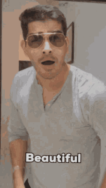a man wearing sunglasses is making a funny face and the word beautiful is above him