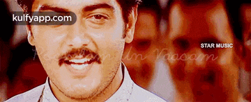 a man with a mustache and a white shirt is smiling .
