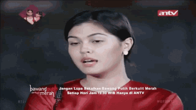 a woman in a red shirt is making a funny face in front of an antv logo