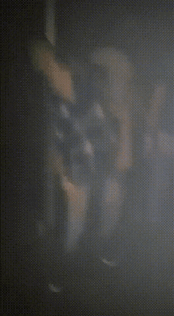 a man in a plaid shirt is standing in the dark