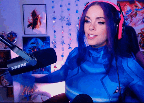 a woman wearing headphones and a shure microphone in a room