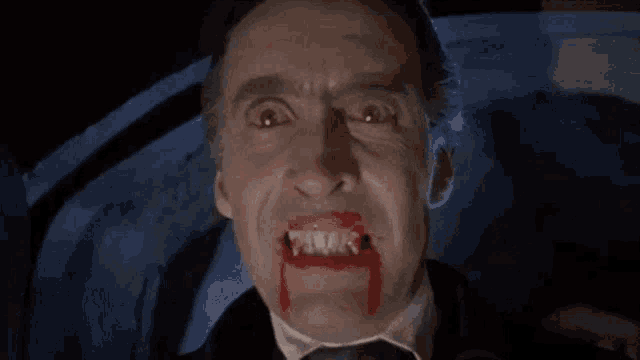 a man with blood dripping from his mouth and teeth .