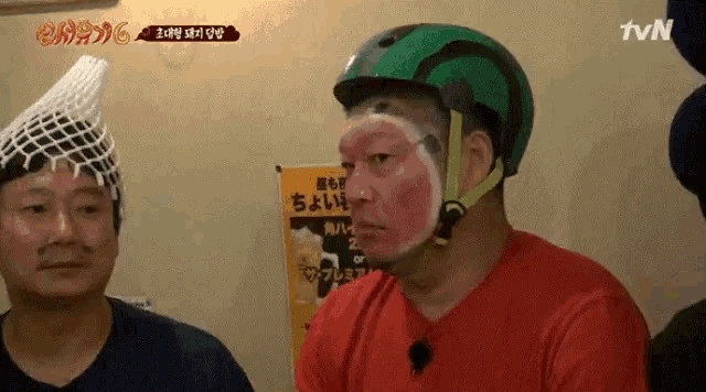 a man wearing a helmet with a watermelon face painted on his face