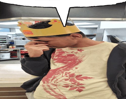a man wearing a burger king crown covering his face