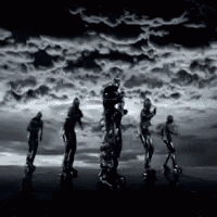 a group of people standing in front of a cloudy sky .