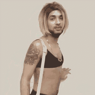 a man with a beard and blonde hair is wearing a bra and a necklace .