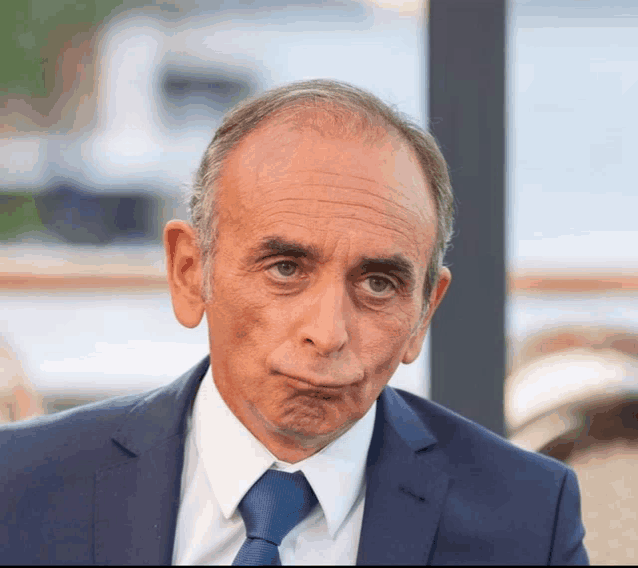a man in a suit and tie makes a funny face
