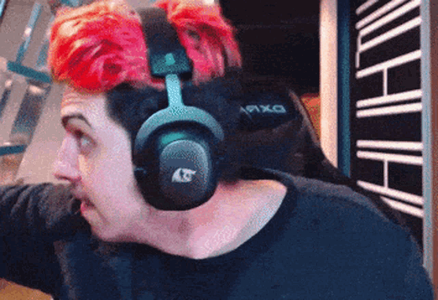 a man with red hair is wearing a pair of headphones with the letter t on it