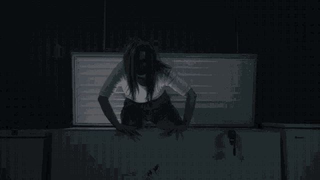 a woman in a white shirt is crawling out of a freezer