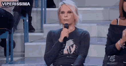 a woman is sitting in front of a microphone with the words viperissima written above her