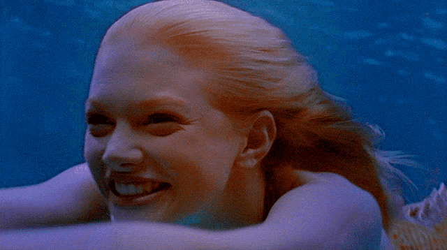 a close up of a woman swimming in the ocean