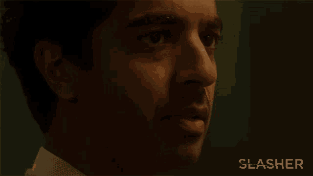 a close up of a man with the word slasher behind him